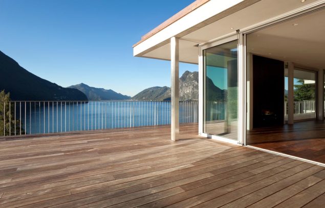 Terrasse d'une maison moderne avec vue sur le lac et les montagnes.