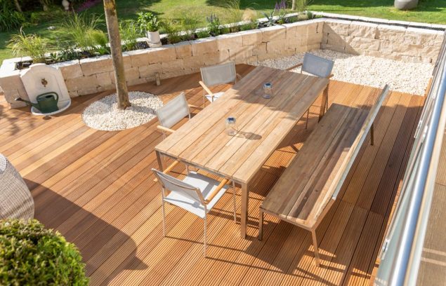 Teak furniture on a modern wooden terrace in summer Mobilier en teck sur une terrasse en bois moderne en été