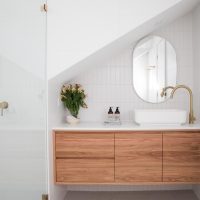 Salle de bain moderne sous les combles, meuble-lavabo avec plan de travail en bois et pierre