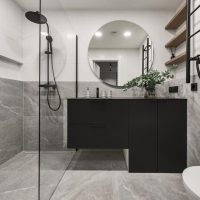 Salle de bains au design minimaliste et moderne, avec carrelage en pierre grise, mobilier noir.