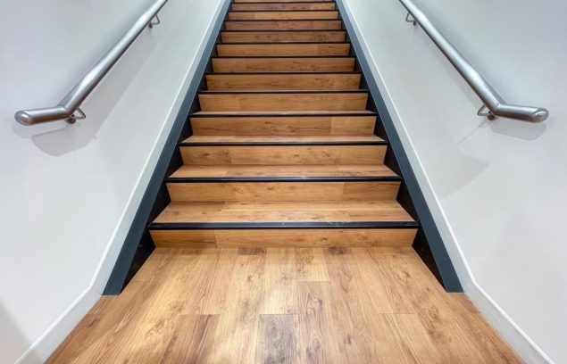 The staircase steps are made of brown wood and have stainless st The staircase steps are made of brown wood and have stainless steel handrails on both sides.